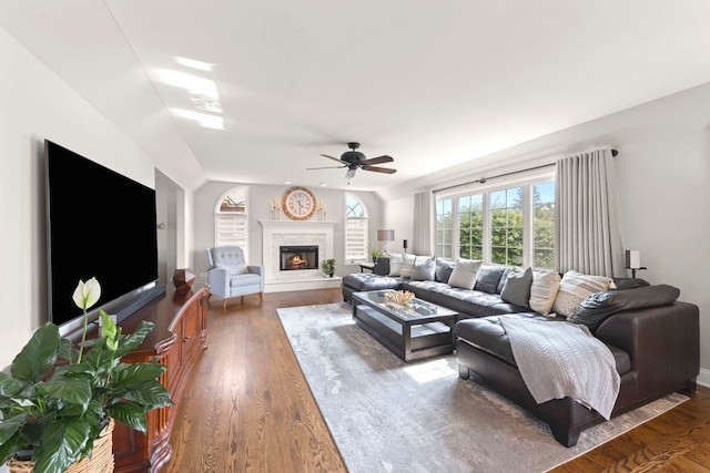 18210 W Winds Ln, Orland Park, IL 60467 - living room with a ceiling fan, dark wood-style flooring, a warm lit fireplace, and baseboards
