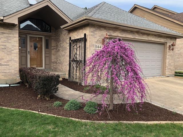 1144 W Trinity Dr, Addison, IL 60101 - view of front of home featuring brick siding, an attached garage, driveway, and roof with shingles