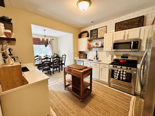963 Oak Ridge Blvd, Elgin, IL 60120 - kitchen with appliances with stainless steel finishes, open shelves, white cabinets, a chandelier, and decorative backsplash