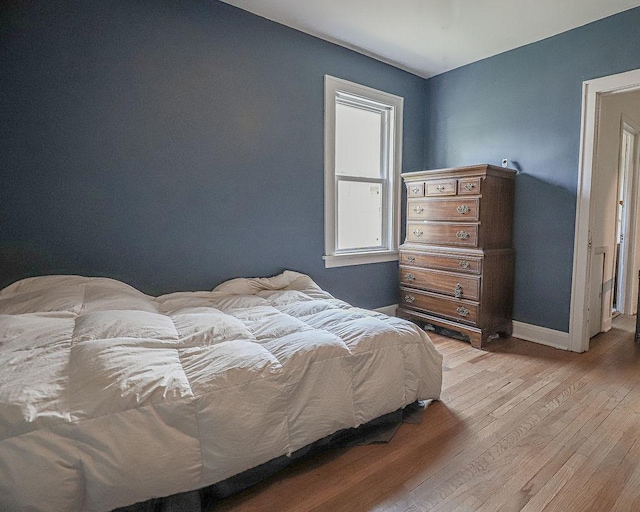 bedroom with light wood-style floors and baseboards