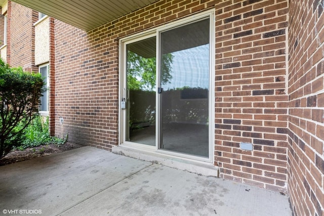 516 N Wilke Rd Unit 105, Palatine, IL 60074 - view of exterior entry featuring brick siding and a patio