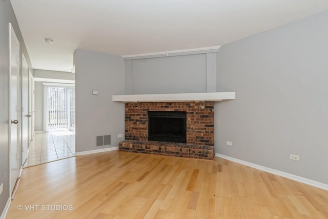 410 Kensington Ct Unit 410, Naperville, IL 60563 - unfurnished living room featuring wood finished floors, baseboards, and a brick fireplace