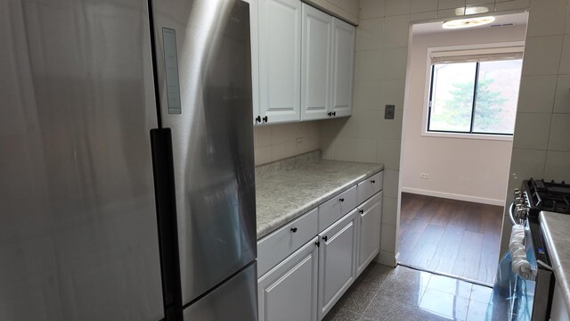 15711 Peggy Ln Unit 7, Oak Forest, IL 60452 - kitchen featuring freestanding refrigerator, gas range oven, white cabinetry, baseboards, and light countertops
