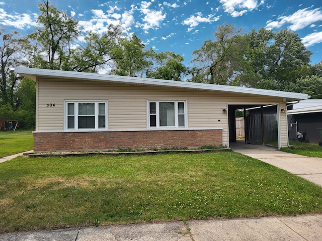 304 Shawnee St, Park Forest, IL 60466 - view of front of property with brick siding, concrete driveway, a front yard, and a carport