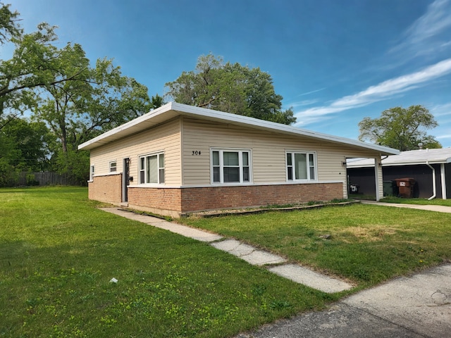 304 Shawnee St, Park Forest, IL 60466 - view of side of property featuring brick siding, a yard, and an attached carport