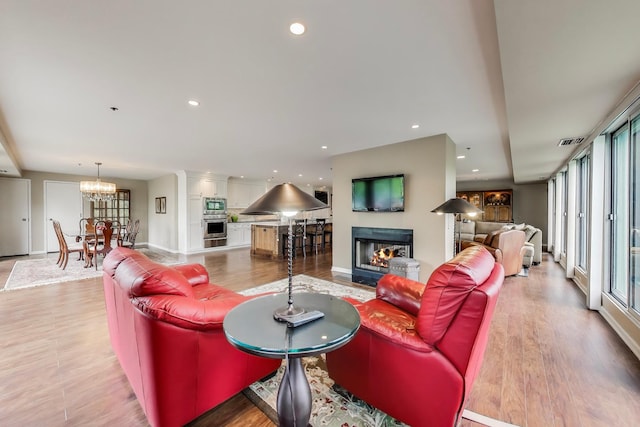 2050 Arbor Ln Unit 301, Northfield, IL 60093 - living area with a multi sided fireplace, light wood-type flooring, a chandelier, and recessed lighting