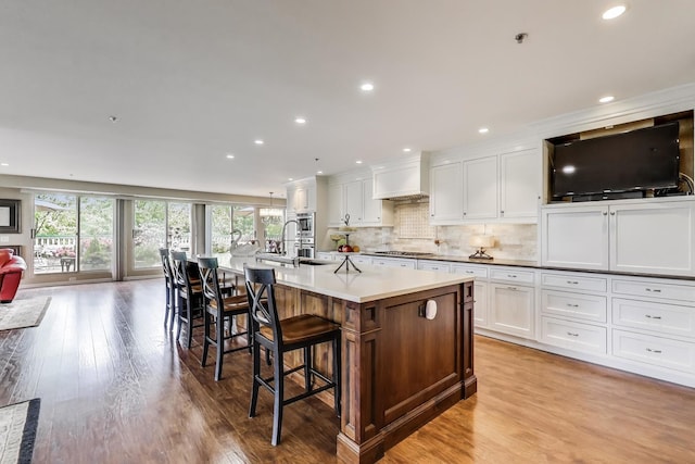 2050 Arbor Ln Unit 301, Northfield, IL 60093 - kitchen featuring white cabinets, light wood-style floors, a spacious island, recessed lighting, and tasteful backsplash