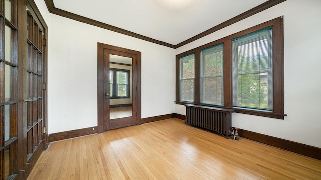 110 E Center St, Mount Morris, IL 61054 - empty room with radiator heating unit, light wood-style floors, baseboards, and ornamental molding