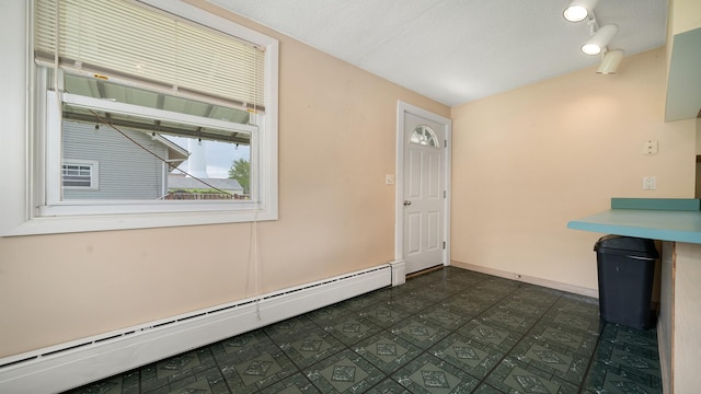 110 E Center St, Mount Morris, IL 61054 - unfurnished dining area with a baseboard heating unit, dark flooring, and baseboards