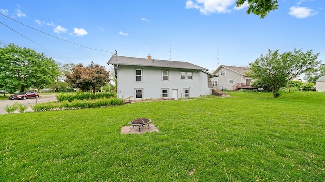 110 E Center St, Mount Morris, IL 61054 - back of property with an outdoor fire pit, stucco siding, a yard, and a chimney