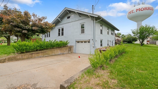 110 E Center St, Mount Morris, IL 61054 - view of home's exterior featuring an attached garage, stucco siding, a yard, and driveway