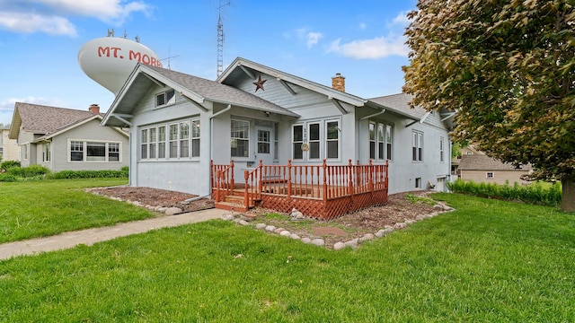 110 E Center St, Mount Morris, IL 61054 - view of front of property with a wooden deck, a front yard, a chimney, roof with shingles, and stucco siding