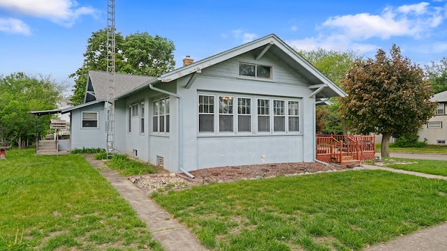 110 E Center St, Mount Morris, IL 61054 - view of home's exterior featuring a chimney, stucco siding, a lawn, and a deck