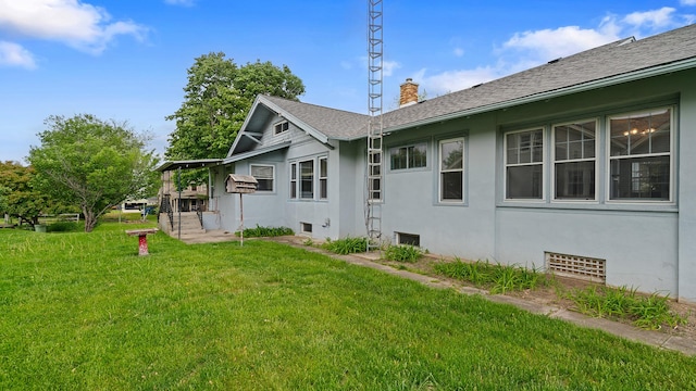 110 E Center St, Mount Morris, IL 61054 - view of property exterior with a chimney, stucco siding, a lawn, and roof with shingles