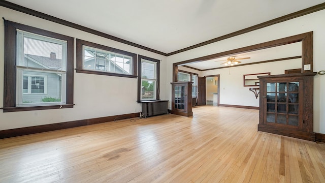 110 E Center St, Mount Morris, IL 61054 - unfurnished living room featuring radiator, light wood-style floors, baseboards, and crown molding
