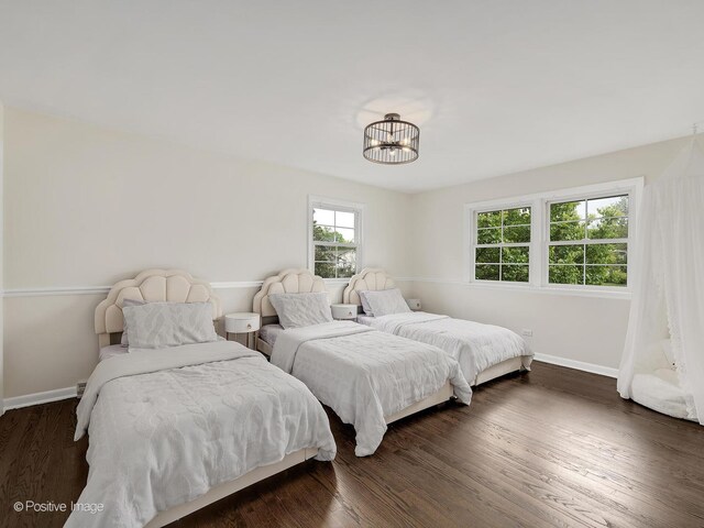 9 Charleston Rd, Hinsdale, IL 60521 - bedroom with multiple windows, baseboards, a chandelier, and dark wood-style floors