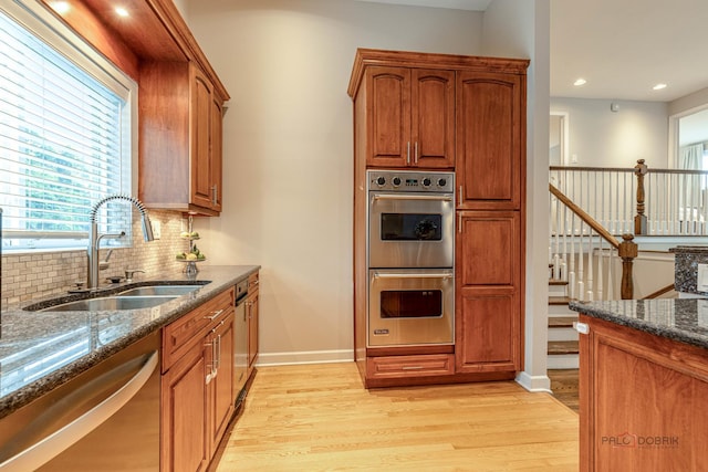 826 Midway Rd, Northbrook, IL 60062 - kitchen with appliances with stainless steel finishes, a sink, light wood-style floors, dark stone counters, and backsplash