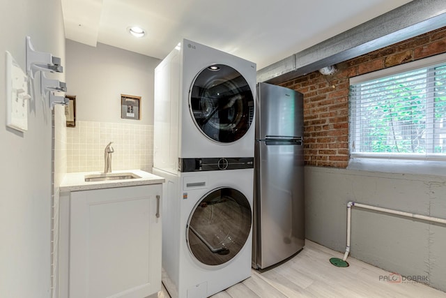 826 Midway Rd, Northbrook, IL 60062 - laundry area featuring stacked washer and clothes dryer, light wood-style flooring, and wet bar