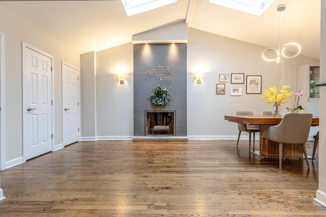 826 Midway Rd, Northbrook, IL 60062 - living room featuring a skylight, vaulted ceiling, a fireplace, and wood finished floors