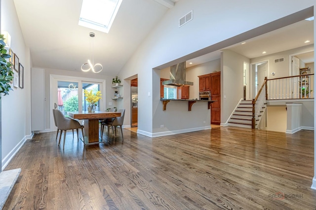 826 Midway Rd, Northbrook, IL 60062 - dining space with a skylight, wood finished floors, stairs, high vaulted ceiling, and baseboards