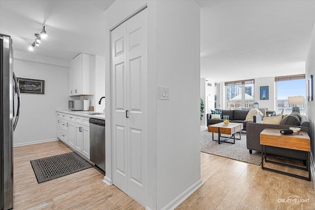 345 N La Salle Dr Unit 3507, Chicago, IL 60654 - kitchen with appliances with stainless steel finishes, light wood-style flooring, white cabinetry, and light countertops
