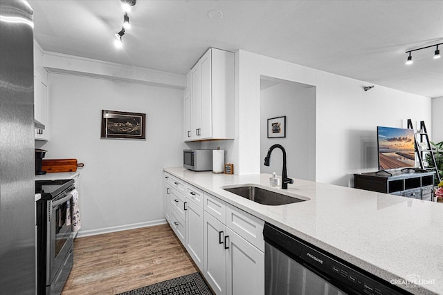 345 N La Salle Dr Unit 3507, Chicago, IL 60654 - kitchen featuring a sink, rail lighting, stainless steel appliances, light wood-style flooring, and white cabinets