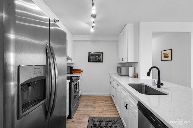 345 N La Salle Dr Unit 3507, Chicago, IL 60654 - kitchen featuring appliances with stainless steel finishes, a sink, white cabinets, light stone countertops, and light wood-style flooring