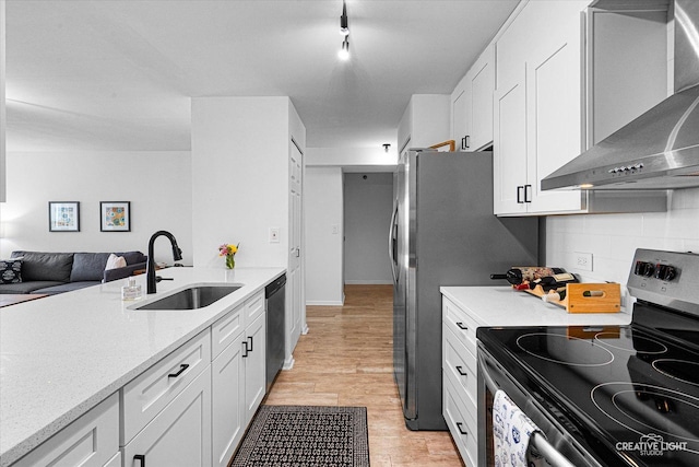 345 N La Salle Dr Unit 3507, Chicago, IL 60654 - kitchen featuring stainless steel appliances, wall chimney exhaust hood, white cabinets, a sink, and decorative backsplash