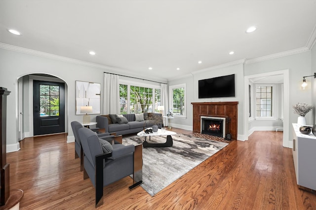 734 Forest Rd, La Grange Park, IL 60526 - living room featuring arched walkways, a fireplace with flush hearth, wood finished floors, baseboards, and crown molding