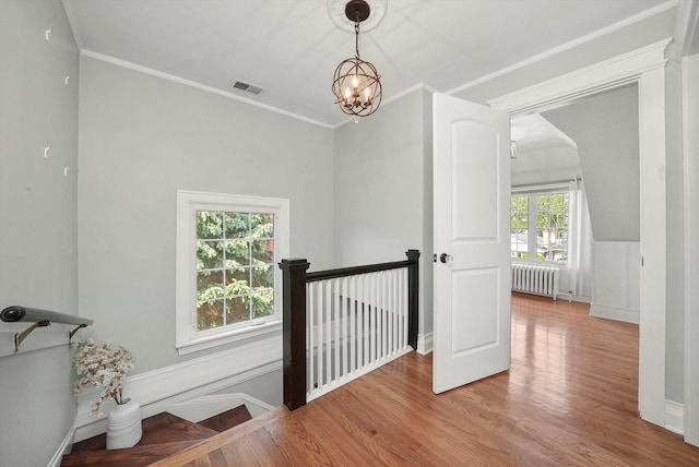 734 Forest Rd, La Grange Park, IL 60526 - hall with radiator, wood finished floors, a chandelier, ornamental molding, and an upstairs landing