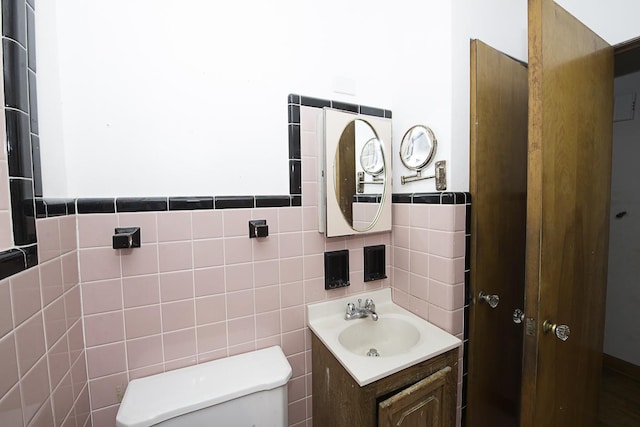 4033 N Austin Ave, Chicago, IL 60634 - bathroom with tile walls, toilet, vanity, and a wainscoted wall