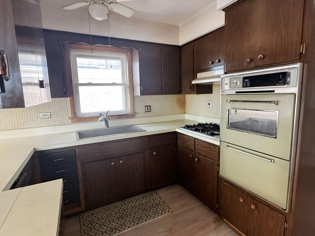 5349 N Meade Ave, Chicago, IL 60630 - kitchen featuring white oven, a sink, gas stovetop, light countertops, and decorative backsplash