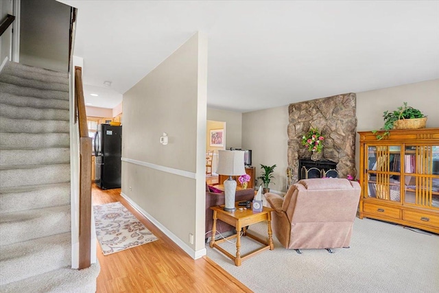 642 Dunham Rd, Gurnee, IL 60031 - living area with stairs, light wood-style flooring, baseboards, and a stone fireplace