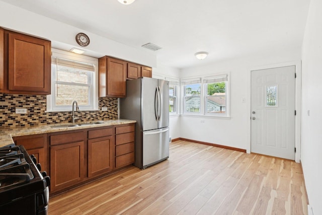 5423 S Rutherford Ave, Chicago, IL 60638 - kitchen with freestanding refrigerator, brown cabinets, tasteful backsplash, and black range with gas stovetop