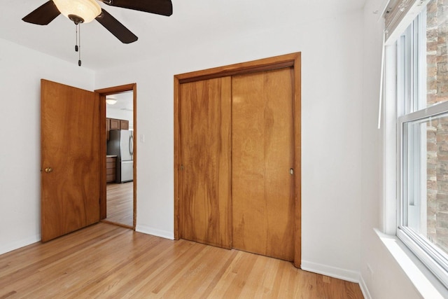 5423 S Rutherford Ave, Chicago, IL 60638 - unfurnished bedroom with freestanding refrigerator, light wood-type flooring, a closet, and a ceiling fan