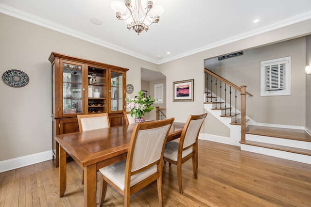 3329 N Bell Ave, Chicago, IL 60618 - dining area with light wood-style floors, stairs, a chandelier, crown molding, and recessed lighting