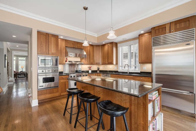 3329 N Bell Ave, Chicago, IL 60618 - kitchen featuring built in appliances, range hood, healthy amount of natural light, brown cabinetry, and ornamental molding