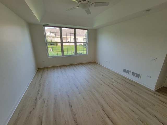 13663 Whittingham Ln, Huntley, IL 60142 - unfurnished room with light wood-style flooring, ceiling fan, a raised ceiling, and baseboards