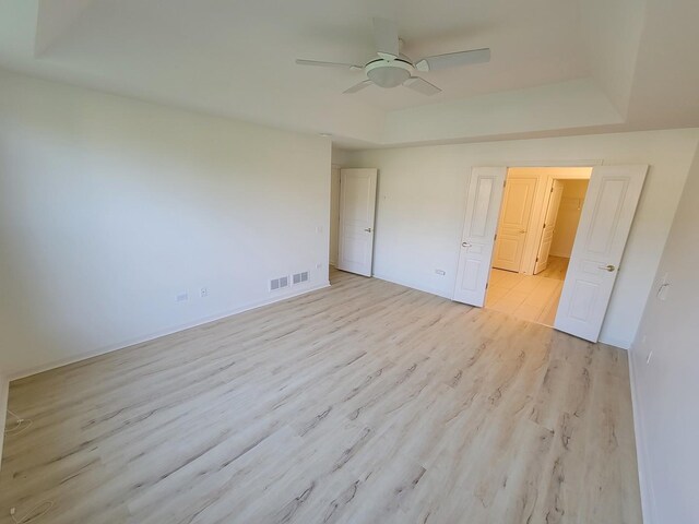 13663 Whittingham Ln, Huntley, IL 60142 - unfurnished bedroom featuring a raised ceiling, light wood finished floors, baseboards, and a ceiling fan