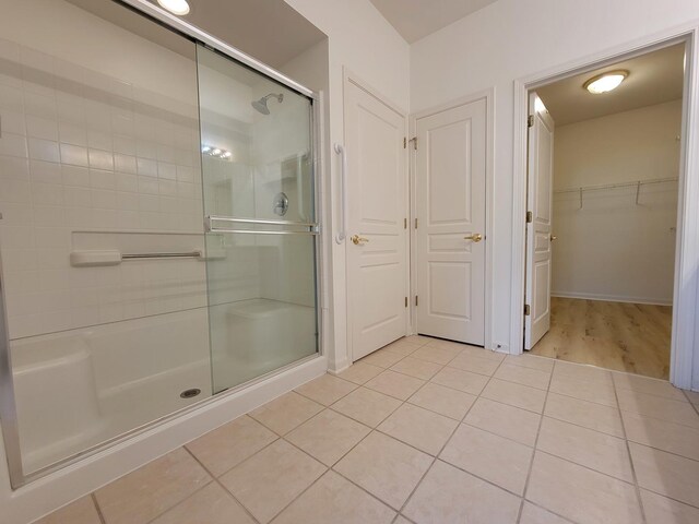 13663 Whittingham Ln, Huntley, IL 60142 - bathroom with a stall shower, tile patterned floors, a walk in closet, and baseboards