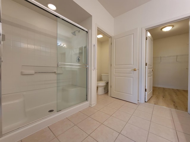 13663 Whittingham Ln, Huntley, IL 60142 - bathroom featuring toilet, a stall shower, tile patterned flooring, a spacious closet, and baseboards