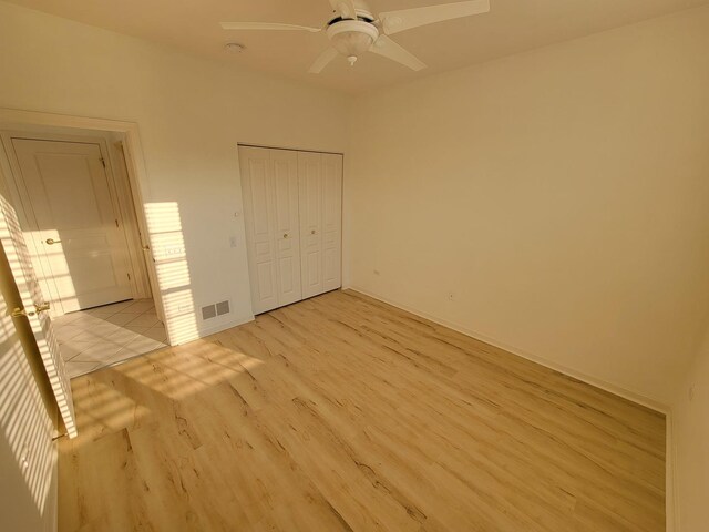 13663 Whittingham Ln, Huntley, IL 60142 - unfurnished bedroom with light wood-style floors, a closet, and a ceiling fan
