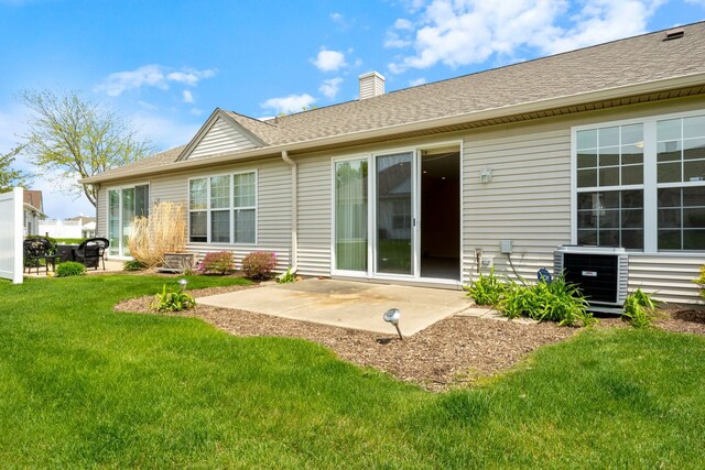 13663 Whittingham Ln, Huntley, IL 60142 - back of property featuring central AC unit, a patio area, a lawn, and a chimney