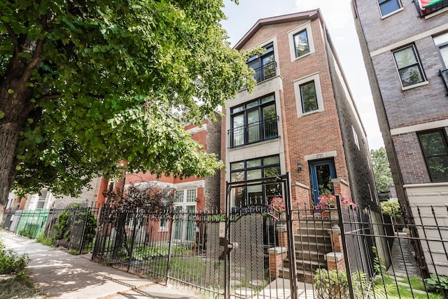 2737 W Thomas St Unit 3, Chicago, IL 60622 - view of front of home featuring brick siding and a fenced front yard