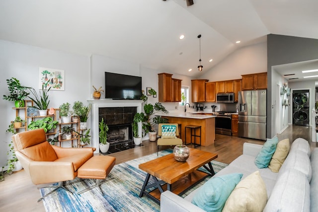 2737 W Thomas St Unit 3, Chicago, IL 60622 - living room with stacked washer / dryer, wood finished floors, a tile fireplace, recessed lighting, and high vaulted ceiling