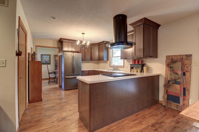 611 Marsha Ln, Rock Falls, IL 61071 - kitchen with appliances with stainless steel finishes, island range hood, a peninsula, light wood finished floors, and a textured ceiling
