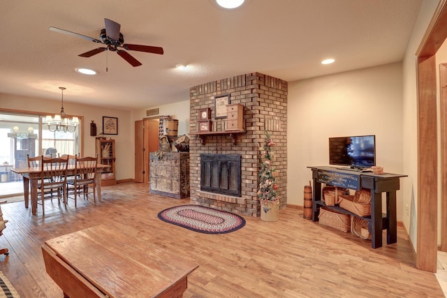 611 Marsha Ln, Rock Falls, IL 61071 - living room featuring wood finished floors, ceiling fan, a brick fireplace, a chandelier, and recessed lighting