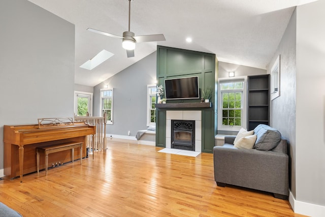 7308 W Lancaster Rd, Peoria, IL 61607 - living area with a skylight, light wood-style floors, ceiling fan, a fireplace, and high vaulted ceiling