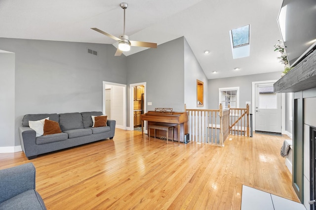 7308 W Lancaster Rd, Peoria, IL 61607 - living area featuring a skylight, wood finished floors, high vaulted ceiling, baseboards, and ceiling fan