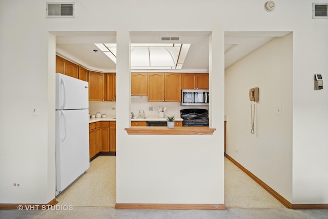 1653 River St Unit 405, Des Plaines, IL 60016 - kitchen with freestanding refrigerator, stainless steel microwave, stove, light countertops, and backsplash